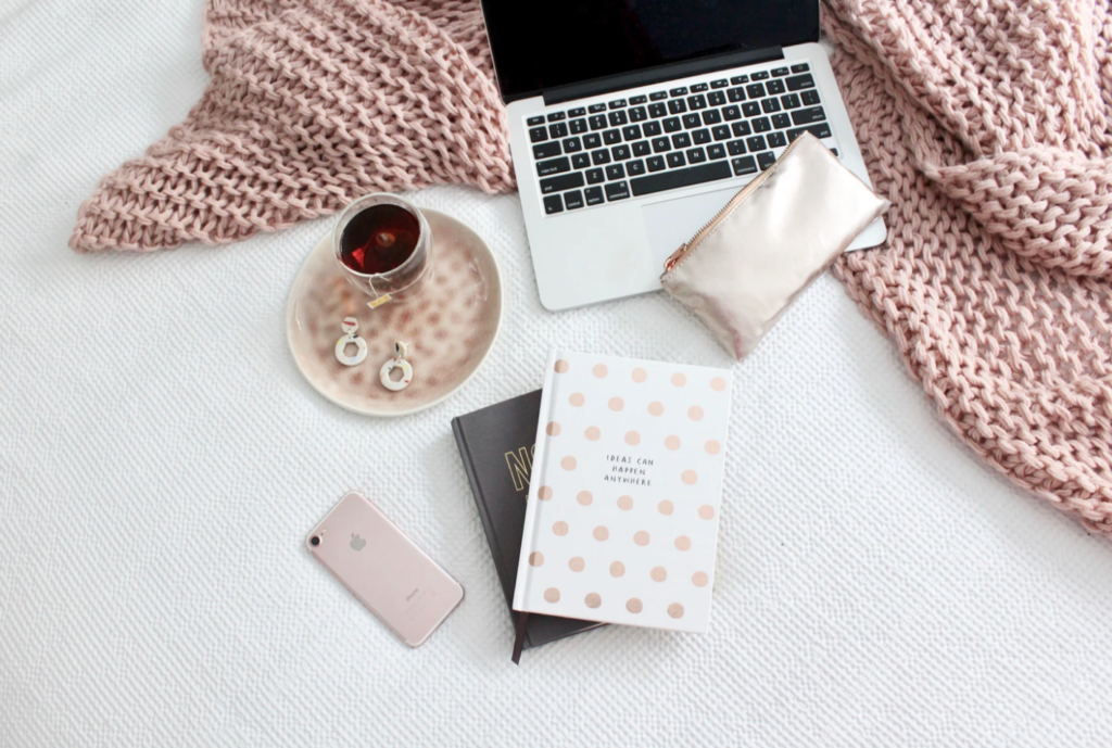 residences pink blanket, phone, laptop on bed