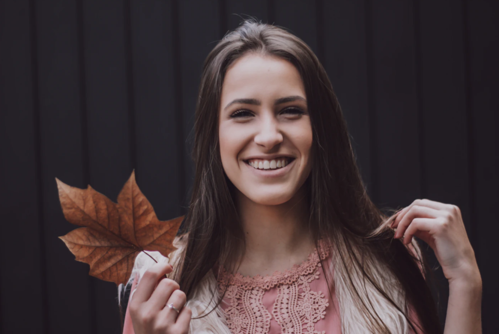 TA woman smiling holding a leaf