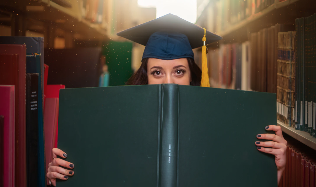 alumni perks graduate student holding giant book