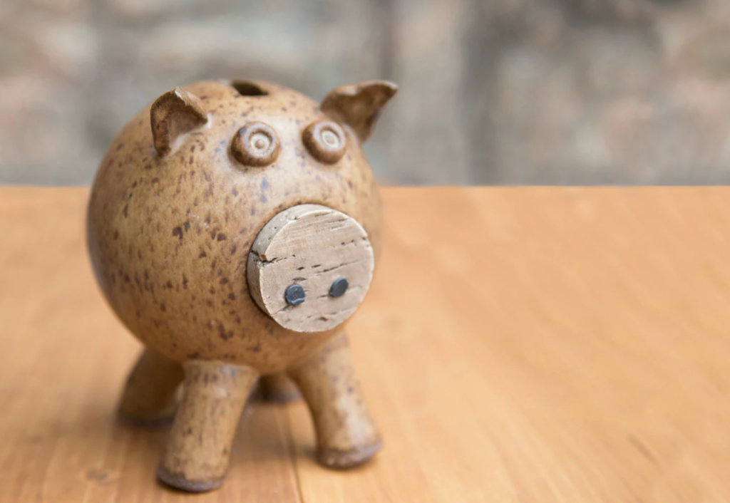 brown piggybank on wooden table holland college financial aid