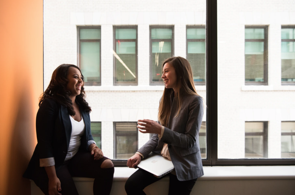 college of the north atlantic's student resources , two students chatting in front of window