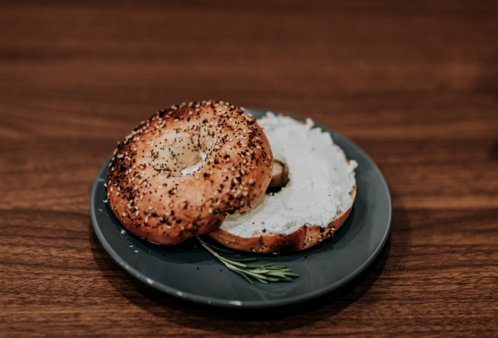 eat at memorial university sesame bagel with cream cheese on plate