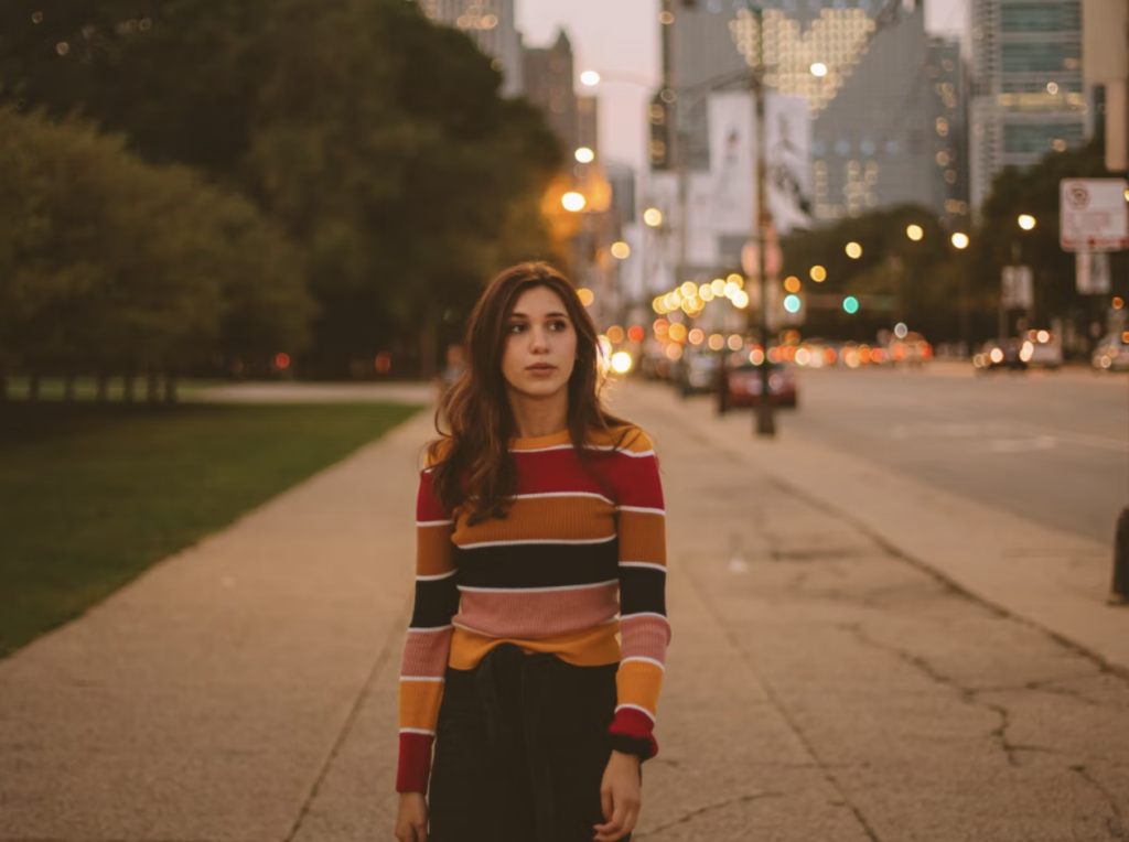 girl with brown hair and striped sweater walking down street, financial aid resources at mcgill