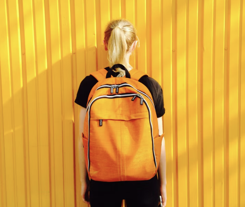 back of blonde ponytail, yellow backpack and background, first year at mcgill