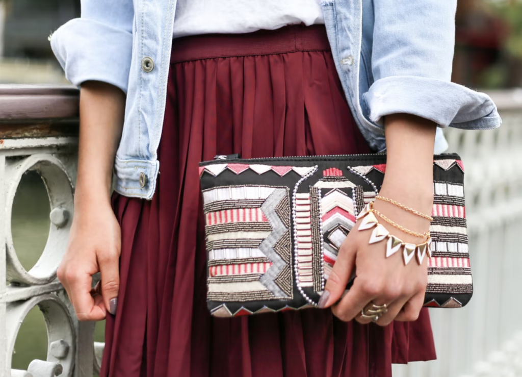 holding a red pattern purse in front of burgundy skirt, waterloo student