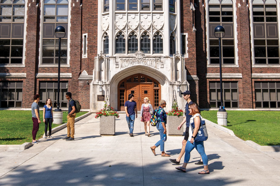 Students walking across University of Windsor campus on a sunny day.